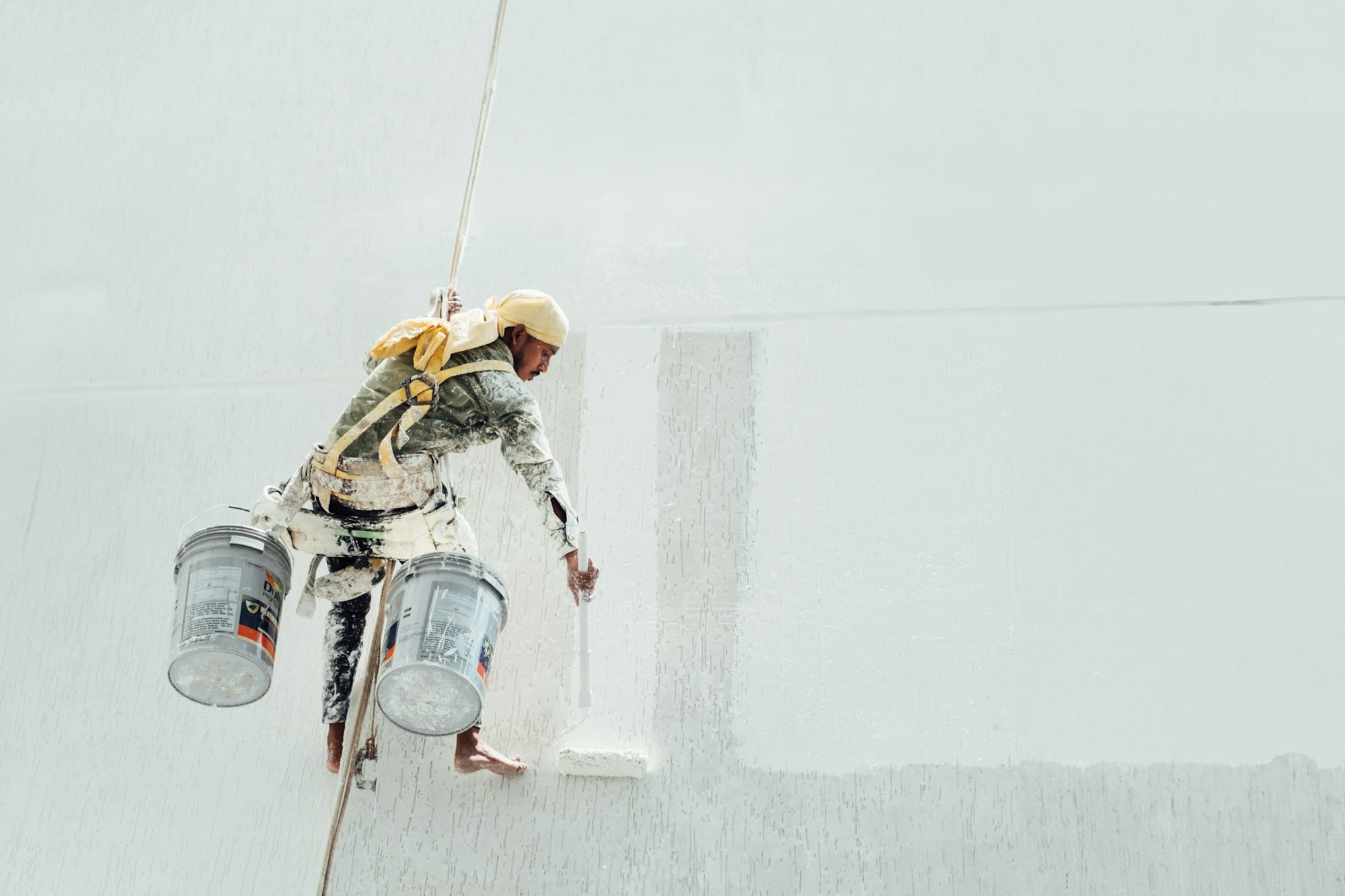 A painter rolling a fresh coat onto a smooth white interior wall