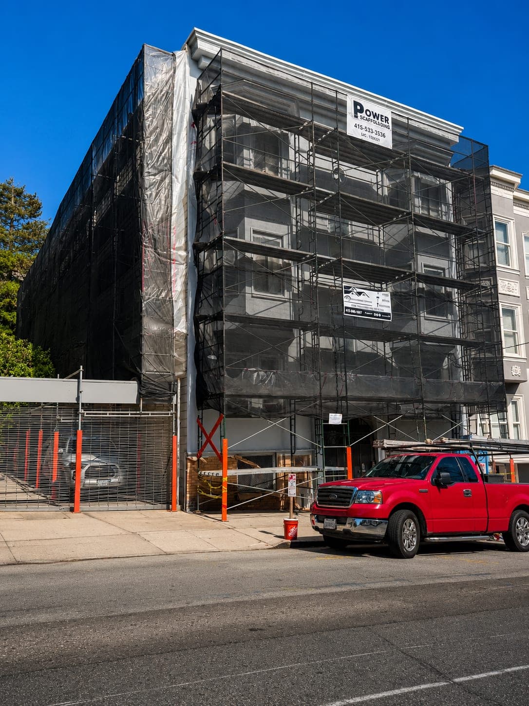Same apartment building from a dramatic low angle with the scaffolding fully in place
