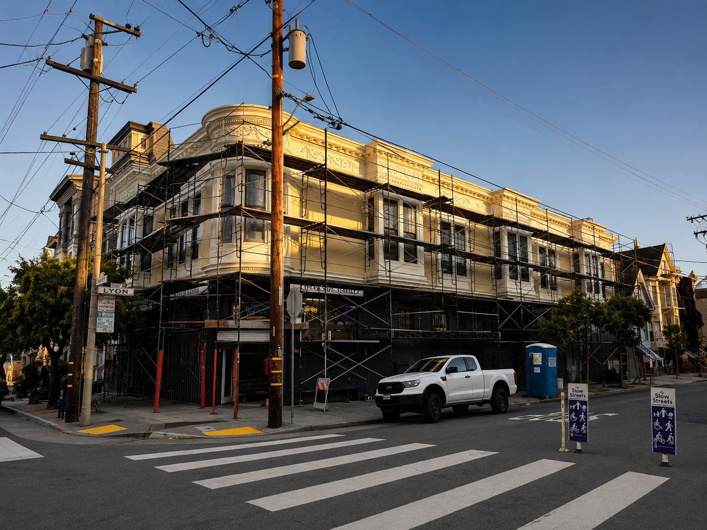 Corner-lot Victorian multi-unit building under restoration with scaffolding, Mission District