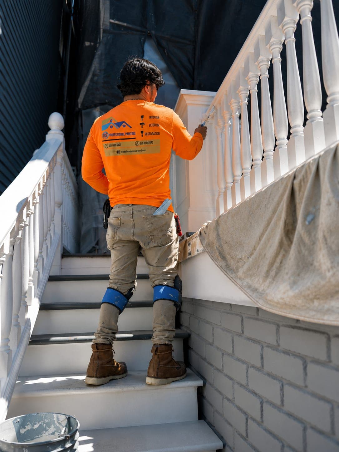 RS Professional Painting crew member hand-painting a white balustrade